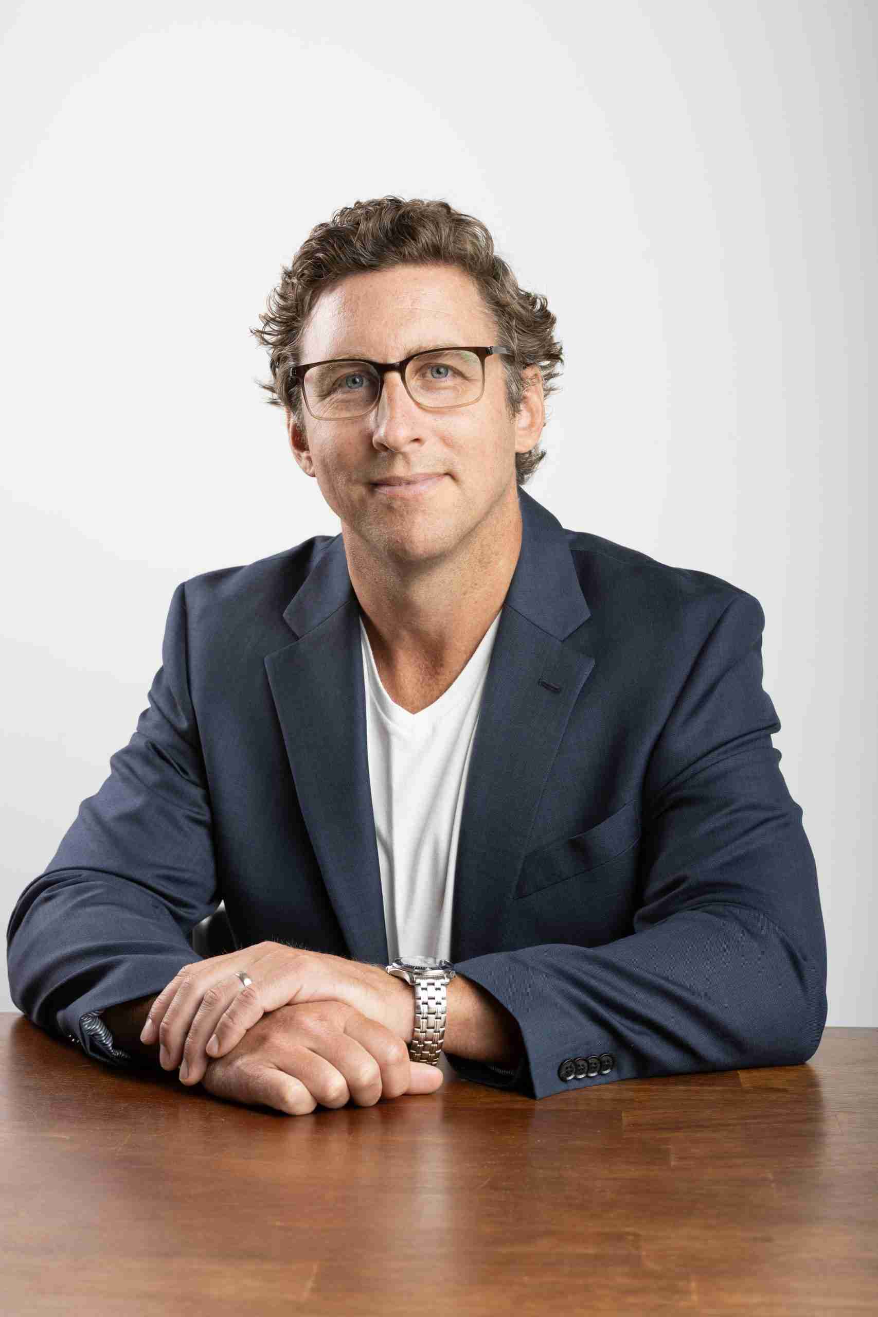 Sitting_table_hands overlap_glasses_T-shirt_jacket